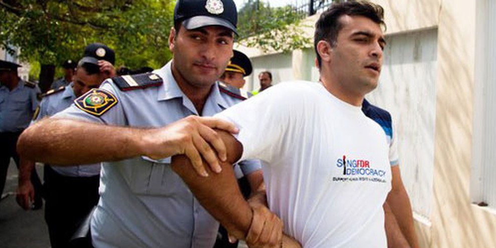 Des policiers arrêtent le défenseur des droits humains Rasul Jafarov. Il s’était engagé pour la démocratie dans son pays. Bakou, juin 2014. © RFE