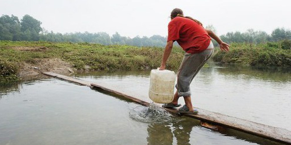 Une enfant Rom récolte chaque jour pour sa famille de l'eau provenant d'un ruisseau sale près de Dobruška, en Slovénie (septembre 2010). © Arne Hodalič 
