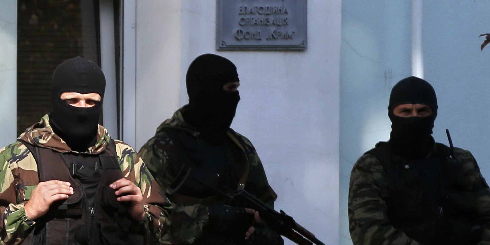 Des hommes armées devant l'entrée du conseil (mejlis) du peuple tatar de crimée. © MAX VETROV/AFP/Getty Images