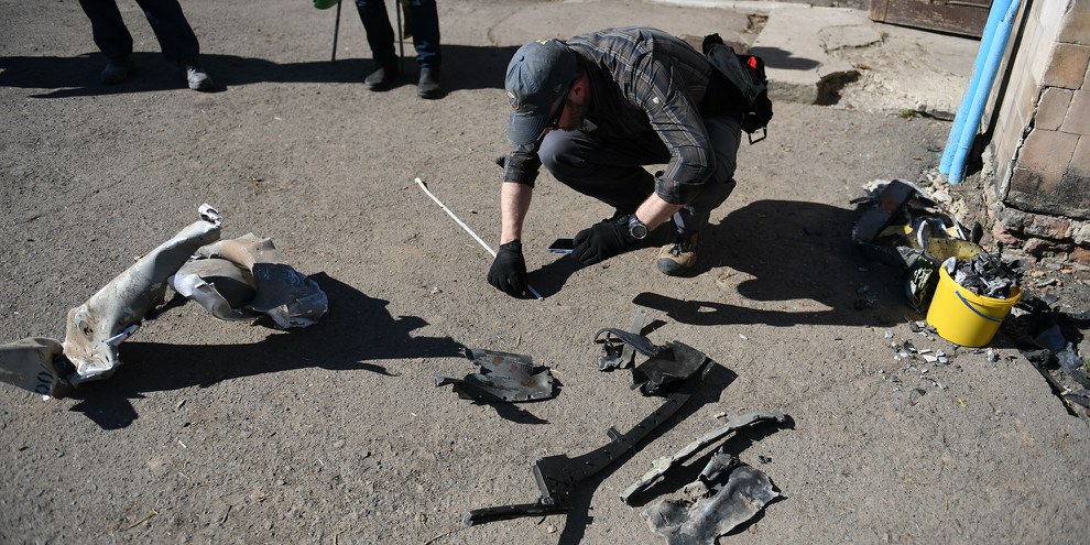 Brian Castner, enquêteur sur les armes au sein de l'équipe d'Amnesty International en train de fouiller dans les décombres des quartiers de Rivne qui ont été touchés par les frappes russes du 14 mars 2022.© Olga Ivashchenko/Amnesty International