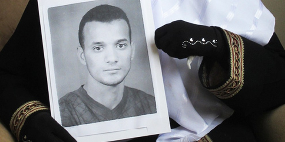 Une photographie d'Ahmad Amer Abd al-Qader, prisonnier exécuté, tenue entre les mains de sa mère. © AI