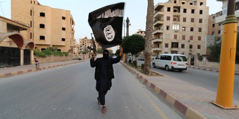 Un combattant de l'Etat Islamique (EI) en Irak brandissant le drapeau de l'EI. © REUTERS/Stringer