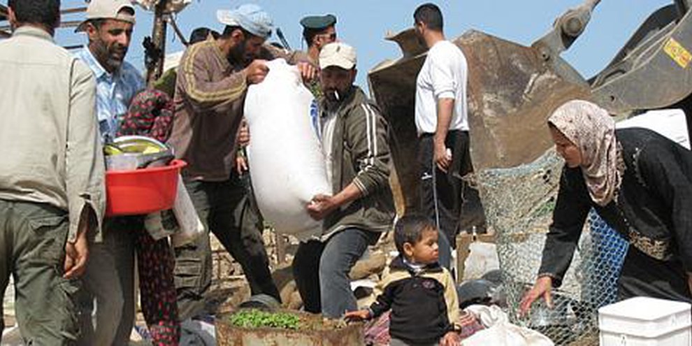 Des habitants et habitantes de Hadidiya tente de récupérer leurs bien en face d'un bulldozer, 2008. © Stop the Wall Campaign
