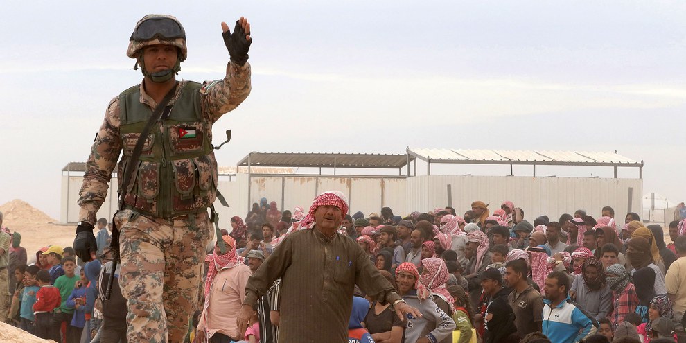 Un soldat jordanien monte la garde tandis que des réfugiés syriens tentent de rejoindre Ruwaished au nord-est de la frontière jordano-syrienne. © KHALIL MAZRAAWI/AFP/Getty Images