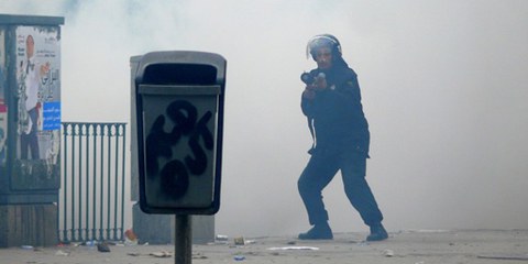  Un policier dans un nuage de gaz lacrimogène à Tunis. Tunisie, le 18 janvier 2011. © Demotix / Hamideddine Bouali 
