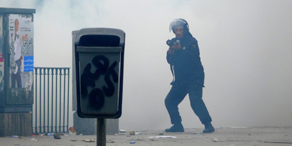  Un policier dans un nuage de gaz lacrimogène à Tunis. Tunisie, le 18 janvier 2011. © Demotix / Hamideddine Bouali 
