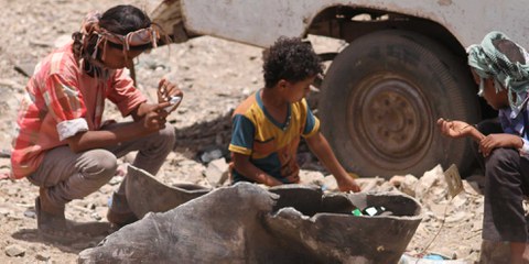 Des enfants du village d'Al-Akma jouant avec les restes d'une bombe MK80 utilisée dans une attaque aérienne.