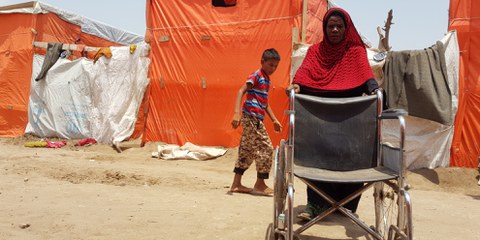 Sur cette photo prise au camp de Mishqafa, Lahj, le 11 juin 2019, Lola Ahmed, la mère d'une jeune fille de 16 ans ayant une déficience physique et intellectuelle, lutte pour pousser un fauteuil roulant donné à sa fille. © Amnesty International
