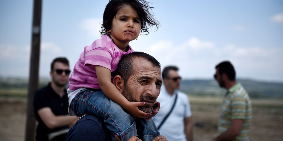 En Grèce, un Syrien et sa fille quittent le camp d'Idomeni suite à une opération d'évacuation par la police grecque. ©Shutterstock