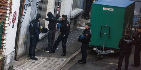 Un officier de police fouillant un homme durant un raid dans un immeuble situé au Pré-Saint-Gervais (nord de Paris), le 27 novembre 2015. © LAURENT EMMANUEL/AFP/Getty Images