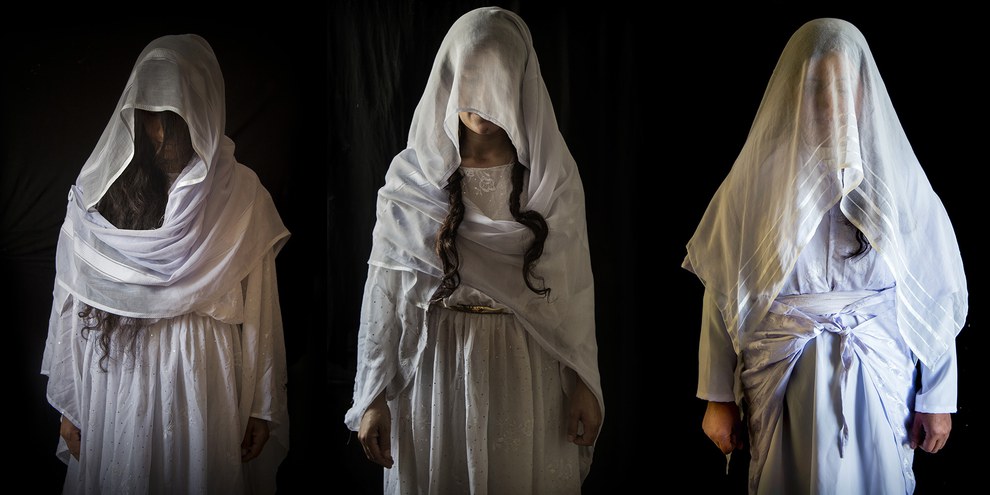 Des femmes yézidies posent dans l’obscurité de leur tente, vêtues d’une robe de mariée traditionnelle yézidie. © Seivan Salim