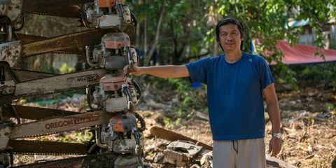 L’activiste Bobby Chan devant une montagne de tronçonneuses confisquées à des trafiquant·e·s de bois qui sévissent dans les forêts de Palawan. ©Nicolas Quénel