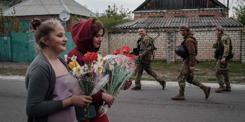 Au milieu des bombardements, la vie de la population ukrainienne suit son cours. Dans le Donbass, des soldats ukrainiens croisent deux adolescentes, qui apportent des fleurs pour célébrer un anniversaire. © Yasuyoshi CHIBA/AFP/KEYSTONE