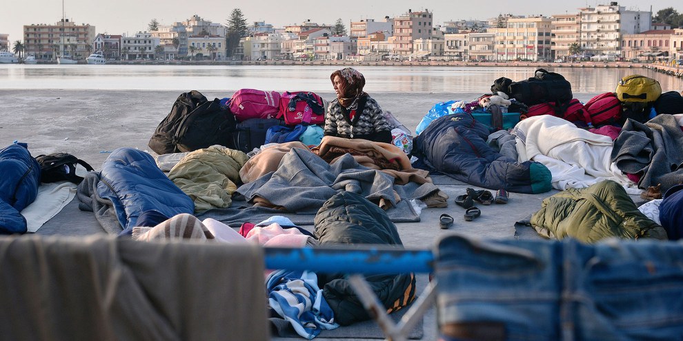 Une femme réfugiée se réveille dans le port de Chios, où les réfugié·e·s et les migrant·e·s passent leur nuit à l'air libre. 5 avril 2016.