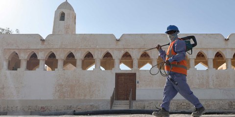 Un ouvrier devant un bâtiment traditionnel de Doha, la capitale du Qatar, où de nombreuses rénovations ont été effectuées en prévision de la Coupe du monde de football. © Karim SAHIB / AFP via Getty Images