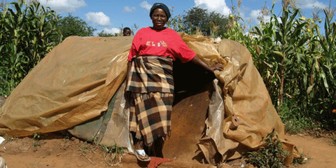 Une femme devant sa maison dans la banlieue d'Harare, Zimbabwe. © AI