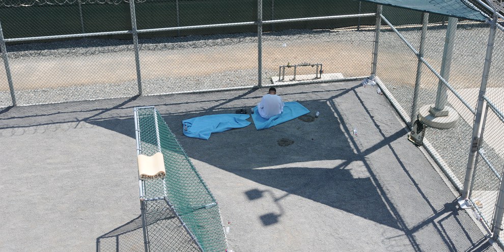 Un détenu assis dans la cour extérieure du centre de Guantánamo, le 18 mars 2011. © US DoD
