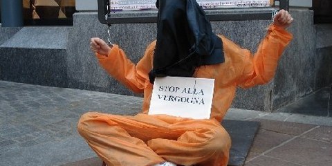 Un militante incappucciato e ammanetato durante la manifestazione 