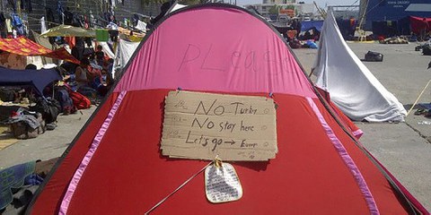 Le richieste dei profughi, su una tenda nel porto di Chio. © Amnesty International
