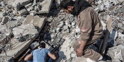 Con l'aiuto di un amico, un sopravvissuto fruga tra le macerie della sua casa, distrutta da un raid aereo del 14 marzo, che ha colpito il quartiere al-Sekar a Mosul est. © Andrea DiCenzo/Amnesty International