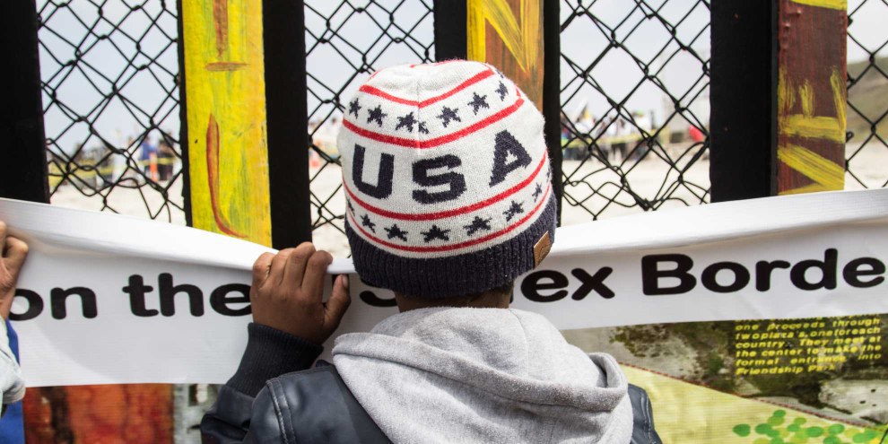 Un bambino guarda Tijuana attraverso il muro della frontiera che separa il Messico dagli Stati Uniti © Amnesty International / Sergio Ortiz Borbolla