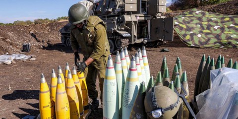 18 ottobre 2023, nord di Israele, nelle vicinanze del confine con il Libano: un soldato dell'esercito israeliano organizza gli obici di artiglieria da 155 mm. © Jalaa Marey / AFP via Getty