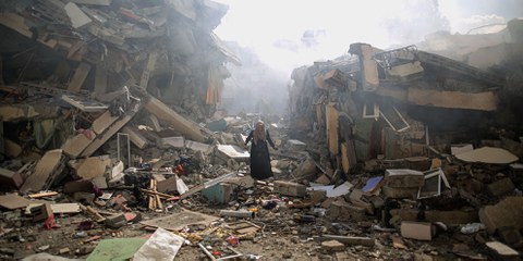 Una donna palestinese tra le macerie di edifici residenziali nel quartiere di al-Zahra, nella Striscia di Gaza, dopo gli attacchi aerei israeliani del 19 ottobre 2023. © Mustafa Hassona/Anadolu via Getty Images